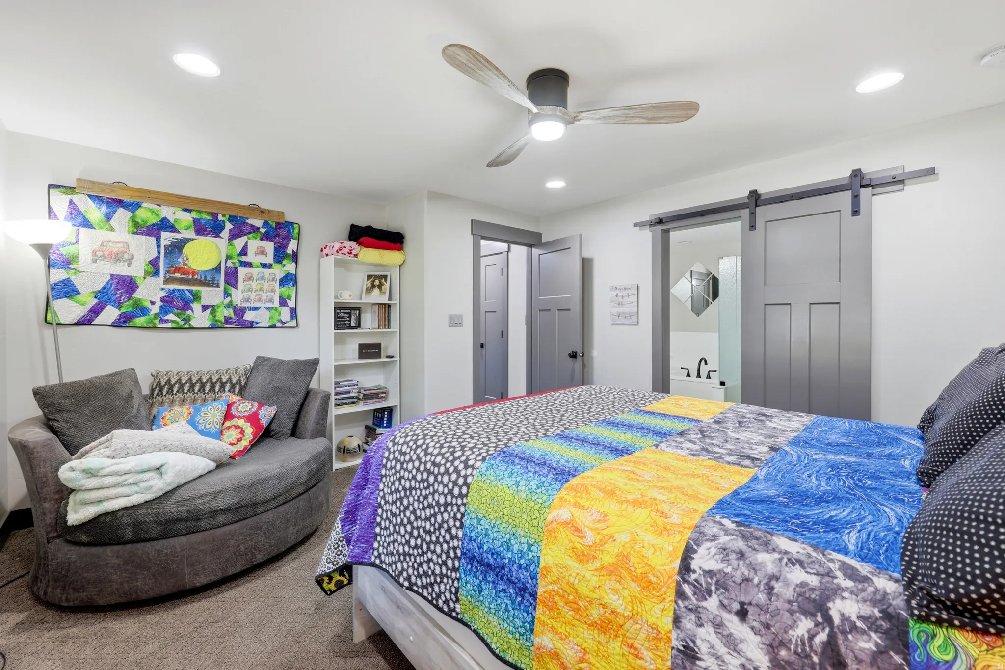 Bedroom featuring a ceiling fan with wood-finish blades, recessed lighting, and a modern barn door leading to an en-suite bathroom