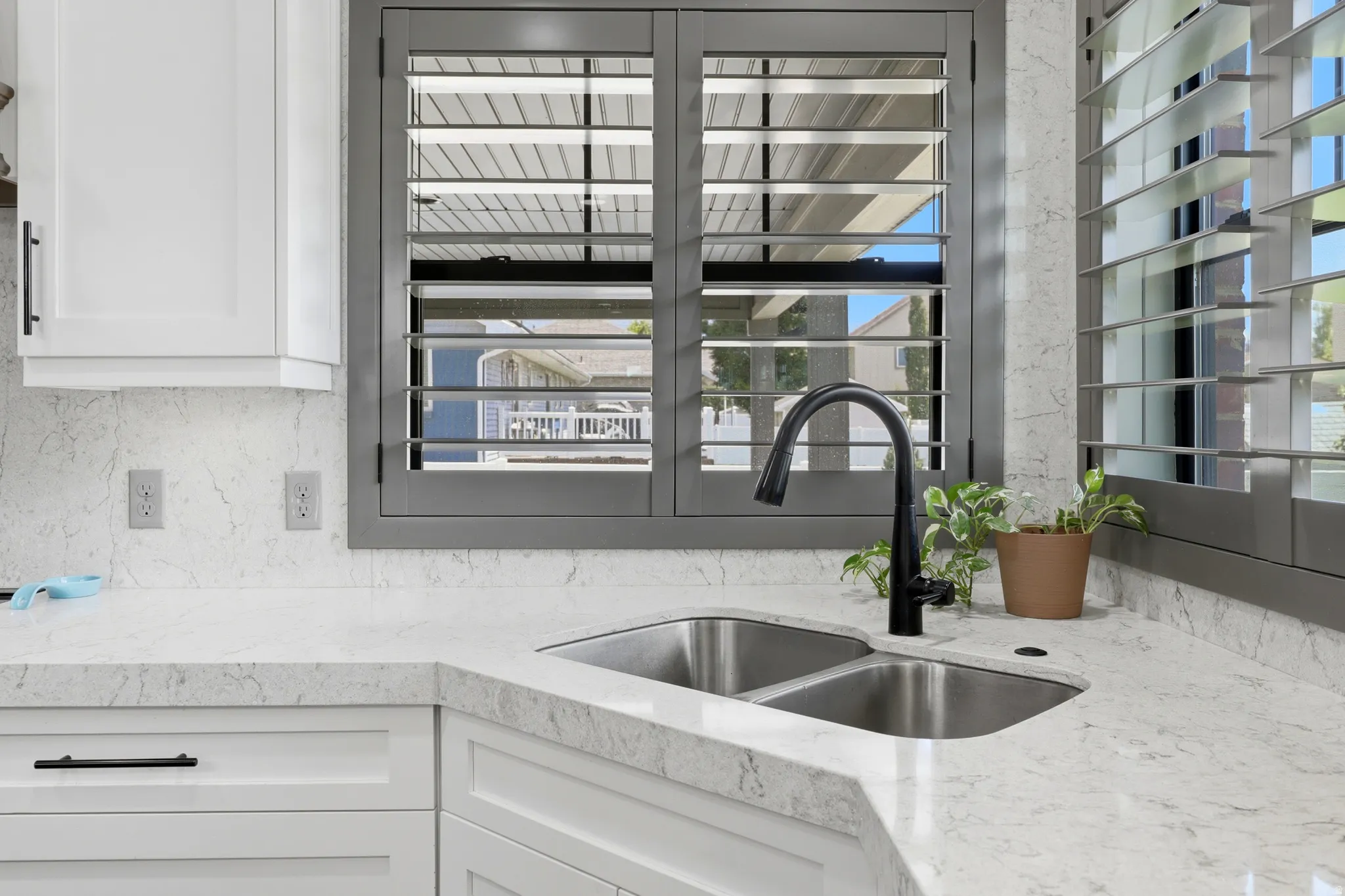 Kitchen sink area featuring light-toned countertops and a double basin stainless steel sink
