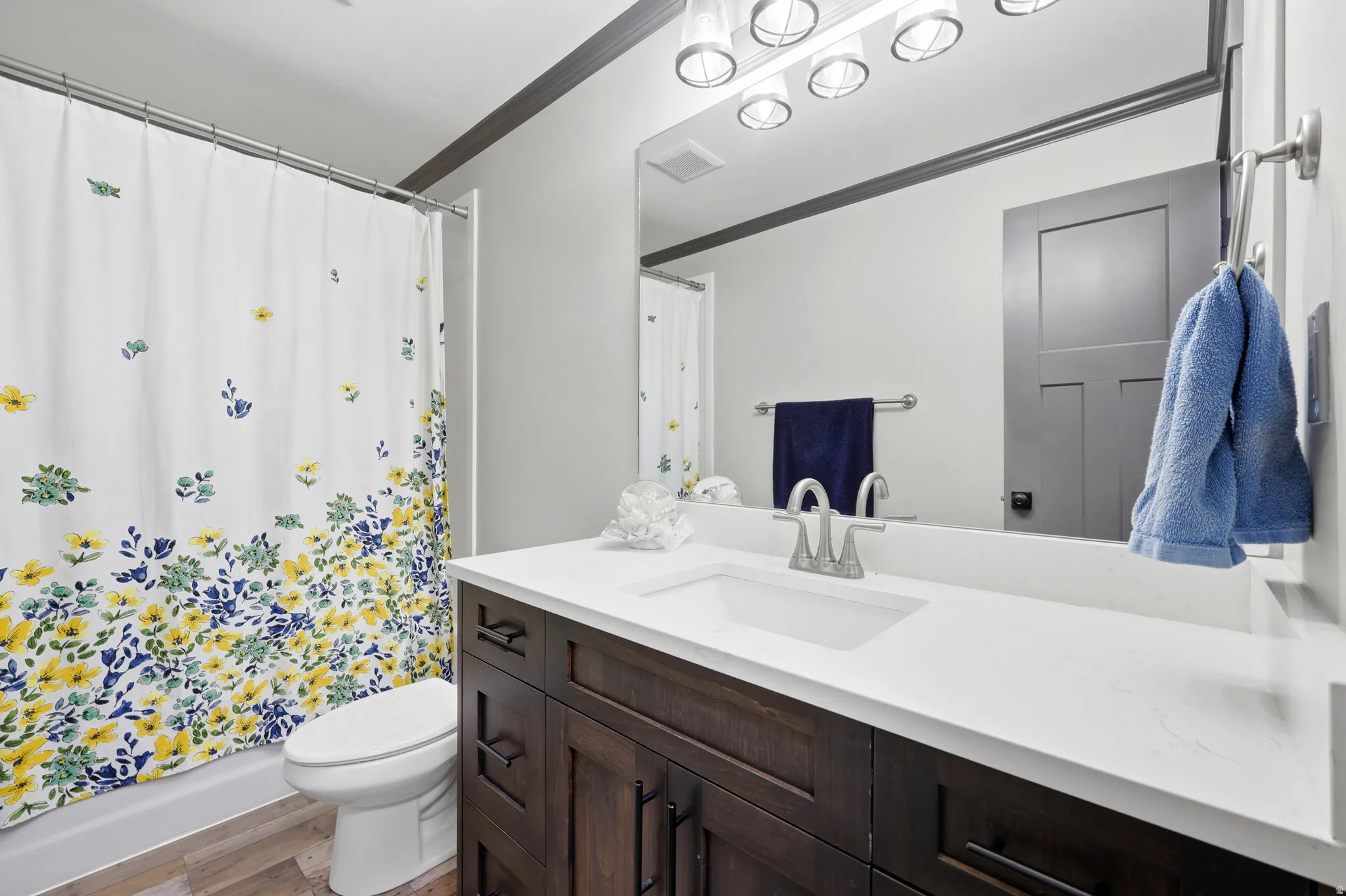 Bathroom featuring a dark wood vanity with a white countertop and an integrated sink