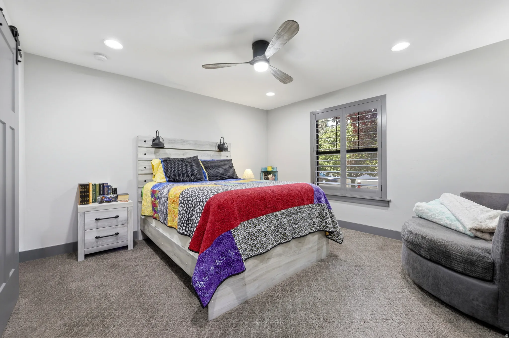 Spacious room with gray wall-to-wall carpeting, featuring recessed lighting and a ceiling fan