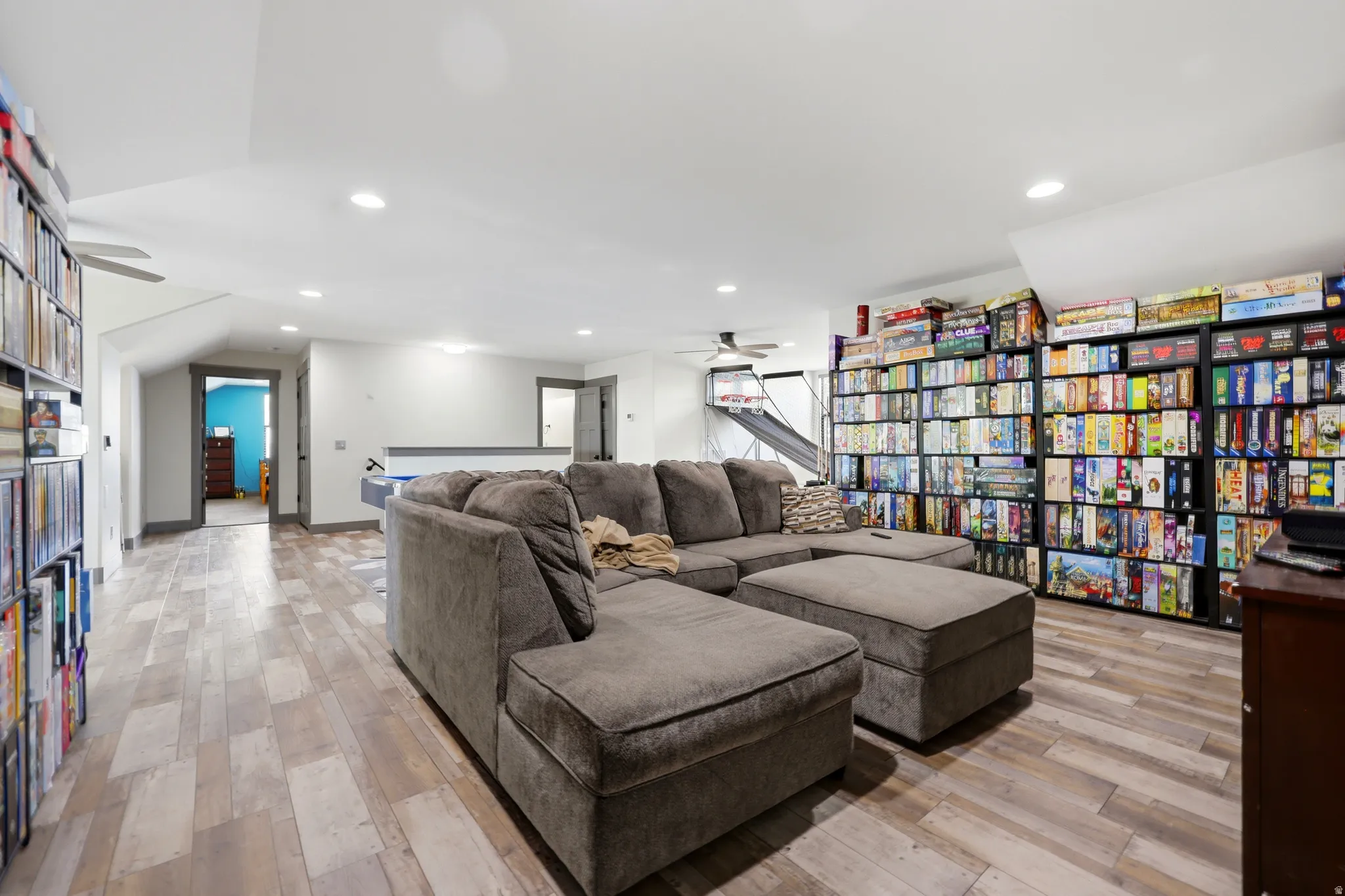 Spacious bonus room featuring wood-finish flooring, recessed lighting, and built-in shelving units