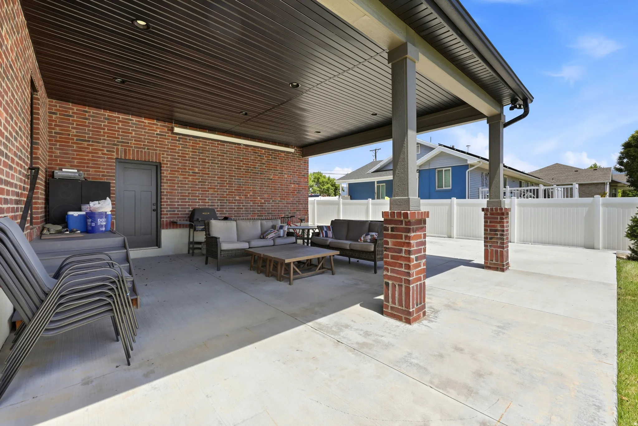 Expansive covered patio featuring brick columns, a flat-panel ceiling with recessed lighting, and a durable concrete surface