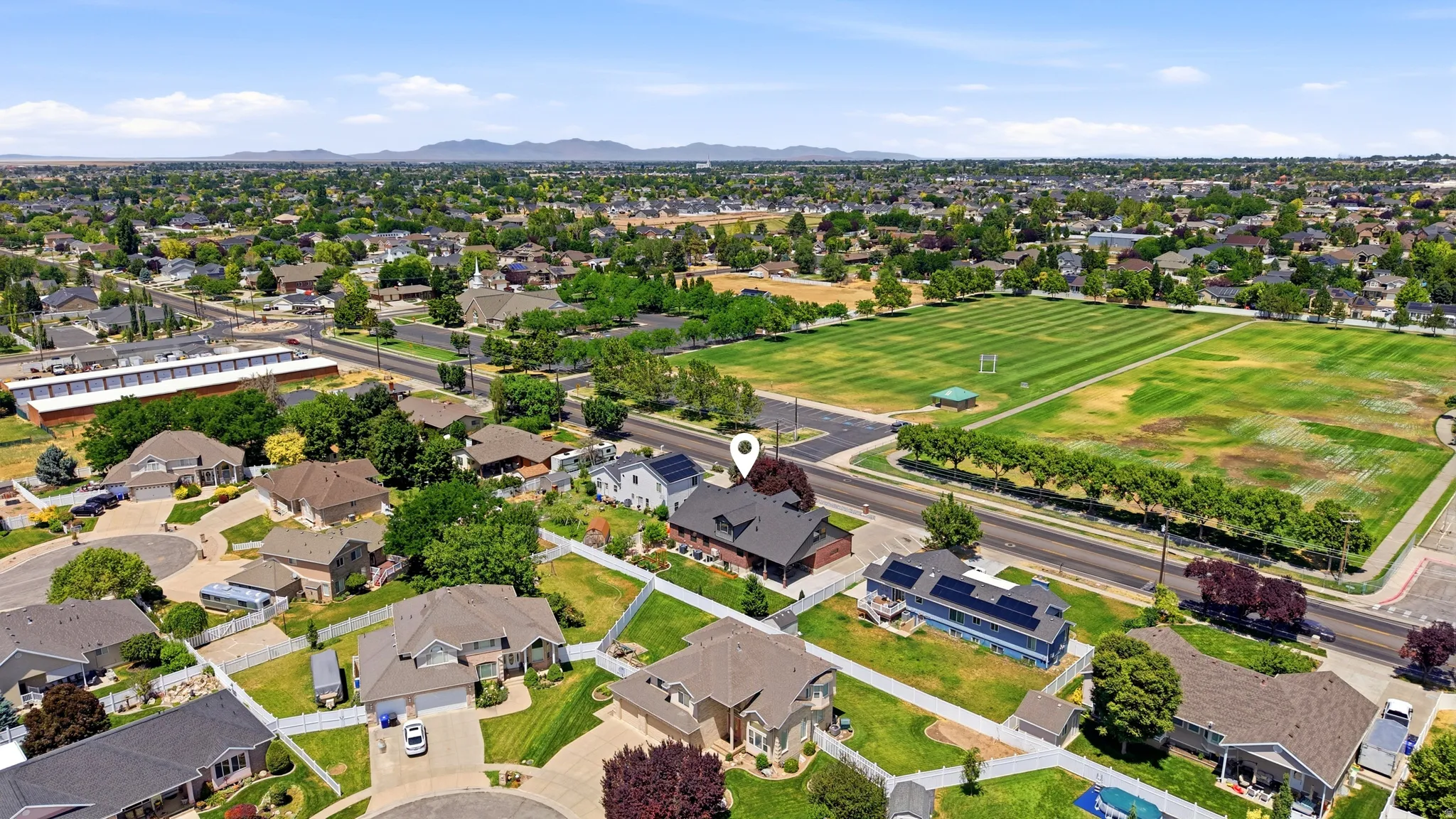 Aerial overview of a residential neighborhood with distant mountain ranges