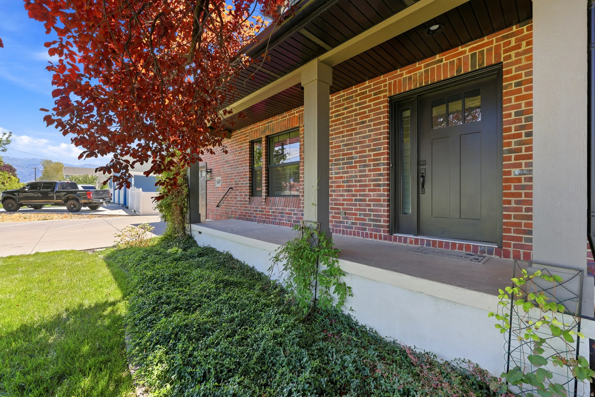 Brick facade featuring a dark paneled entry door with transom windows and a side light