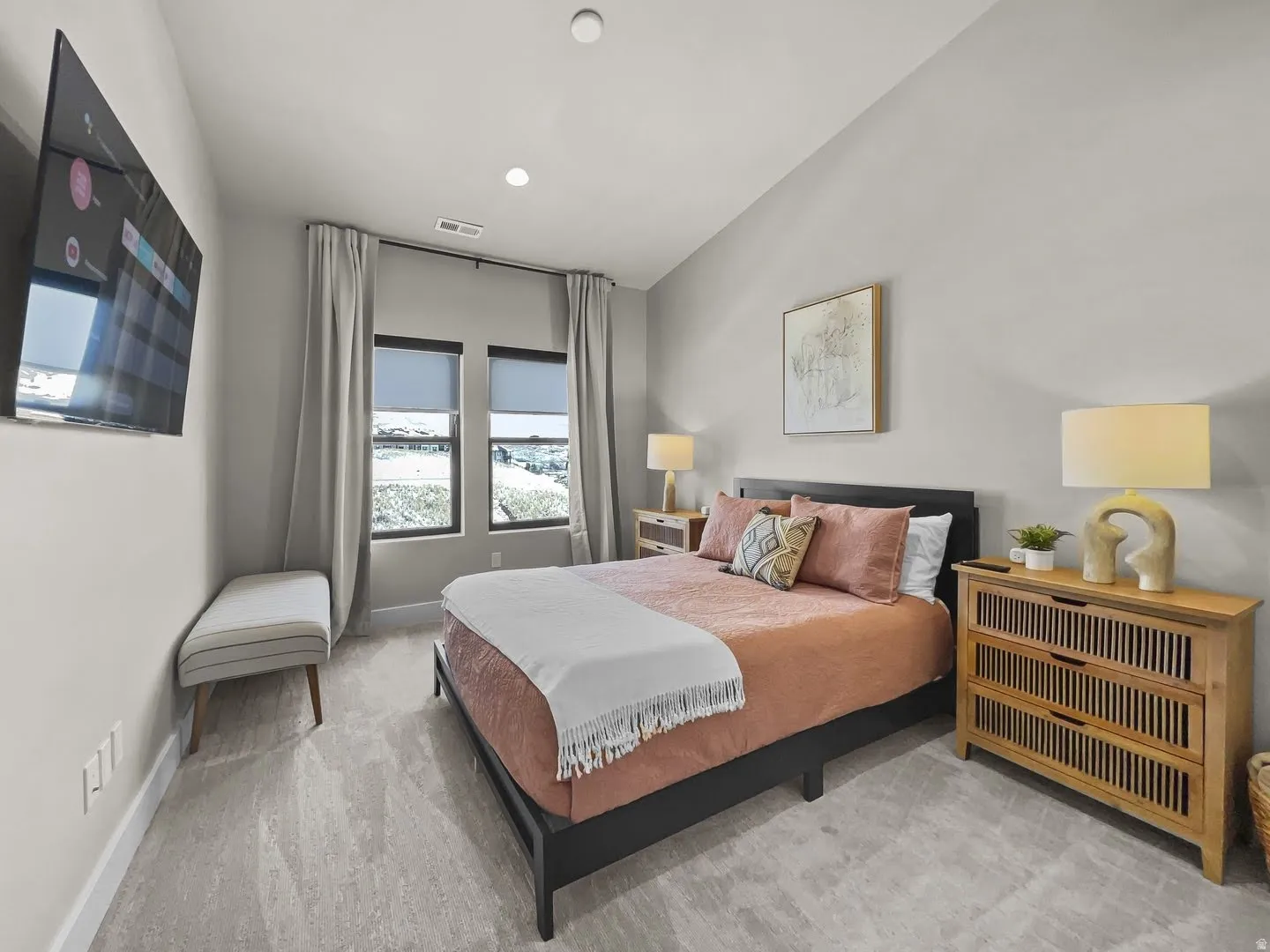 Plush carpeting and light gray wall tones create a neutral palette