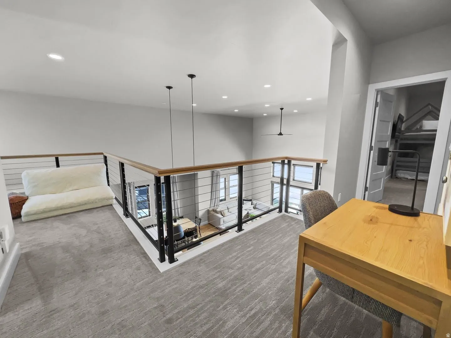 Upper-level landing featuring a wood and metal railing overlooking the floor below