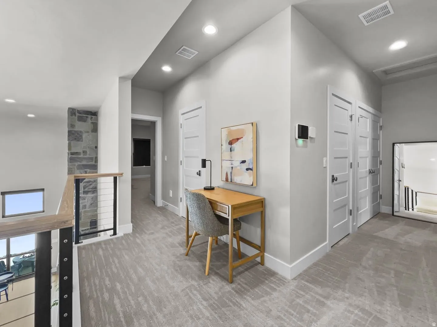 Upper-level hallway with textured carpeting and recessed lighting