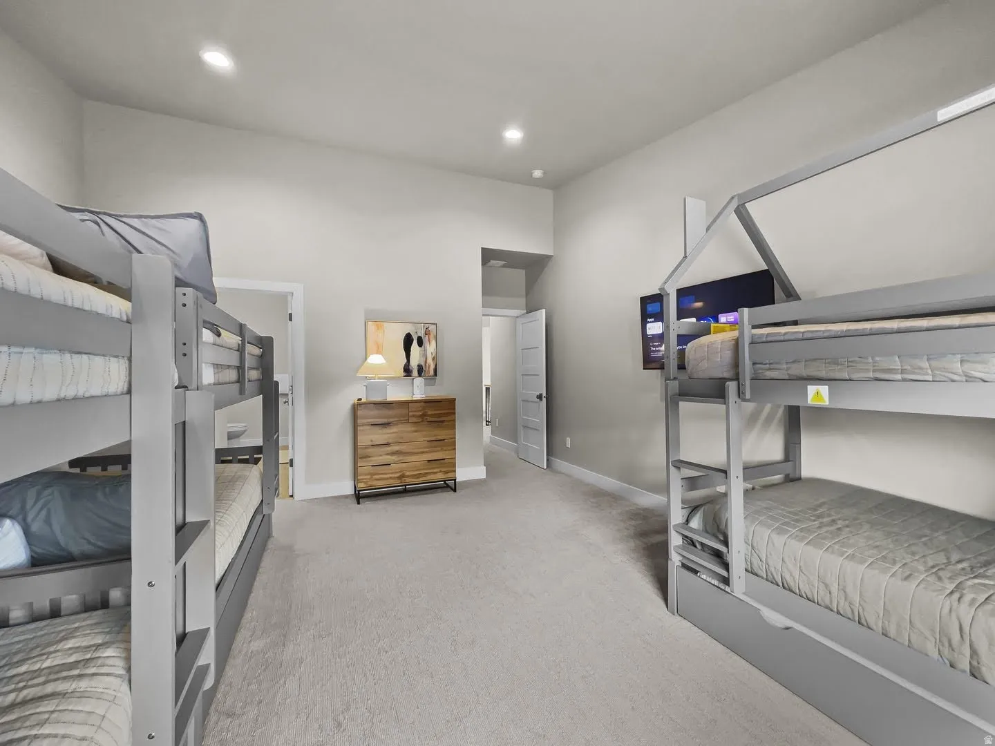 Carpeted room featuring multiple bunk beds, recessed lighting, and a wood-finish chest of drawers