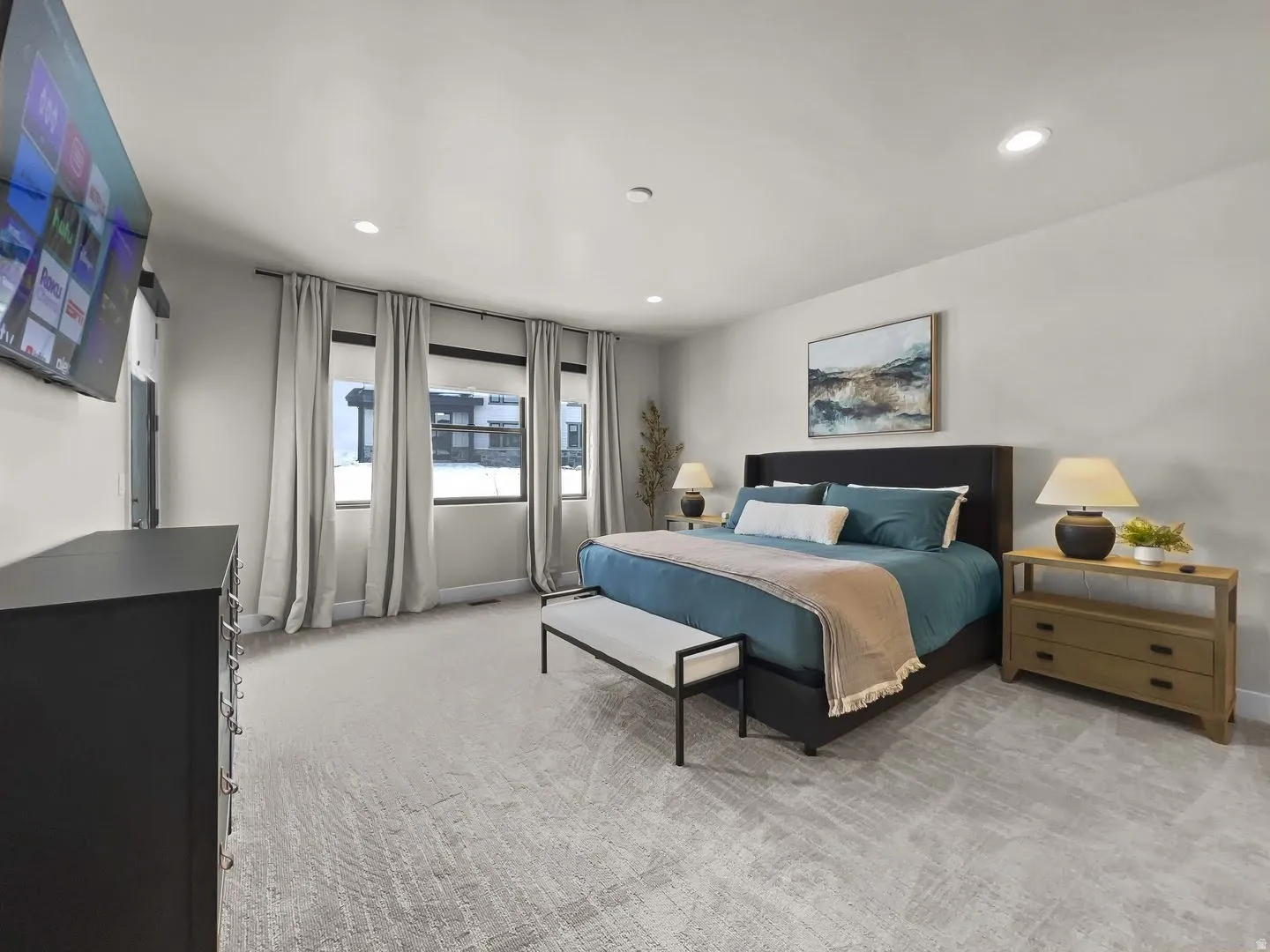 Spacious room featuring light-colored walls and patterned carpeting