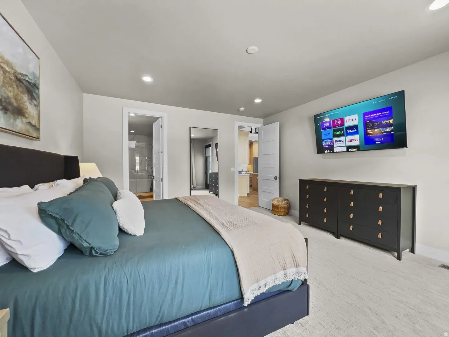 Spacious bedroom with light-colored carpeting and recessed lighting