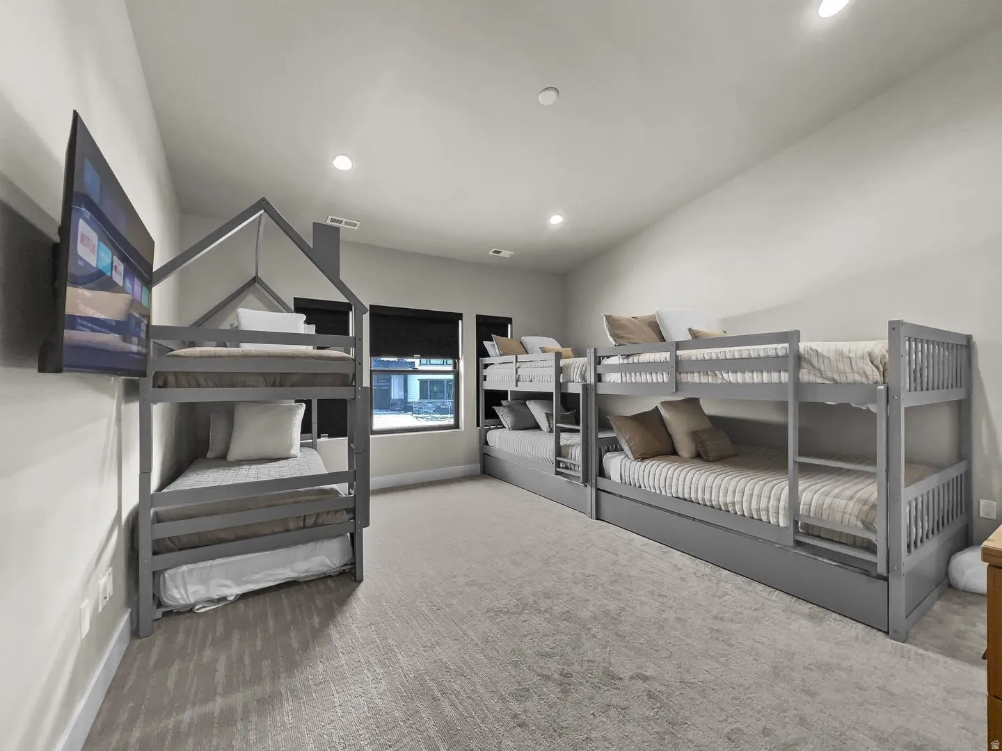 Spacious room featuring light gray walls, recessed lighting, and soft carpet flooring