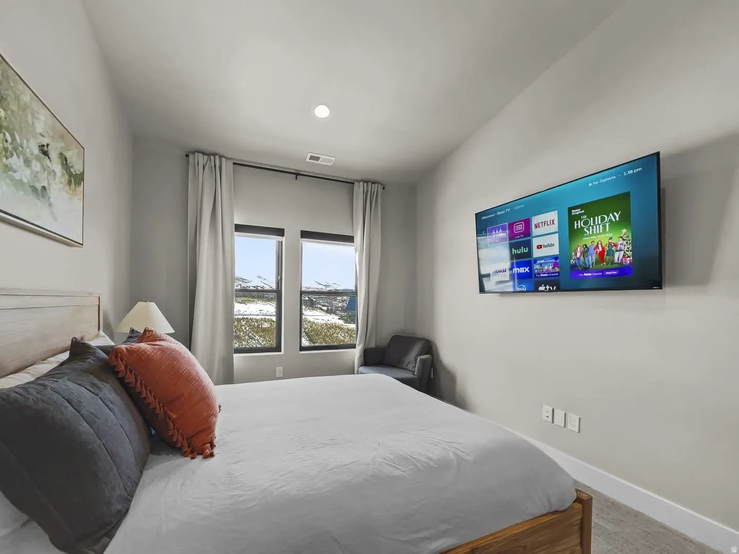 Bedroom featuring neutral wall colors, carpet flooring, a recessed ceiling light, and windows showcasing a distant mountain landscape