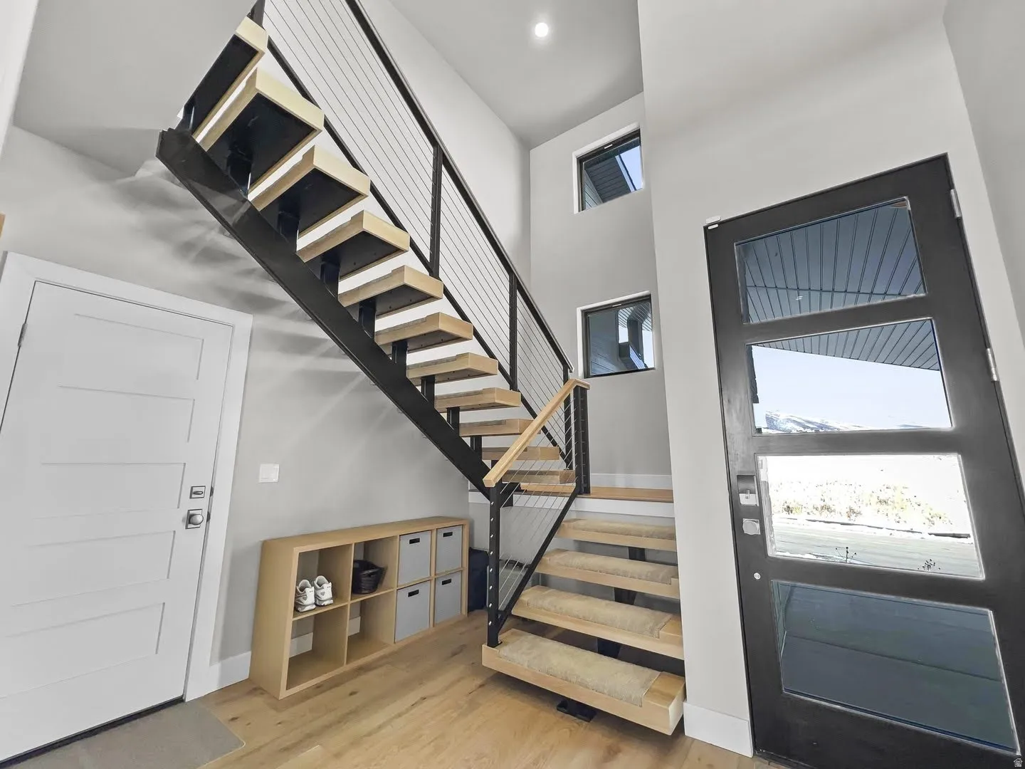 Modern floating staircase with natural wood treads and cable railing