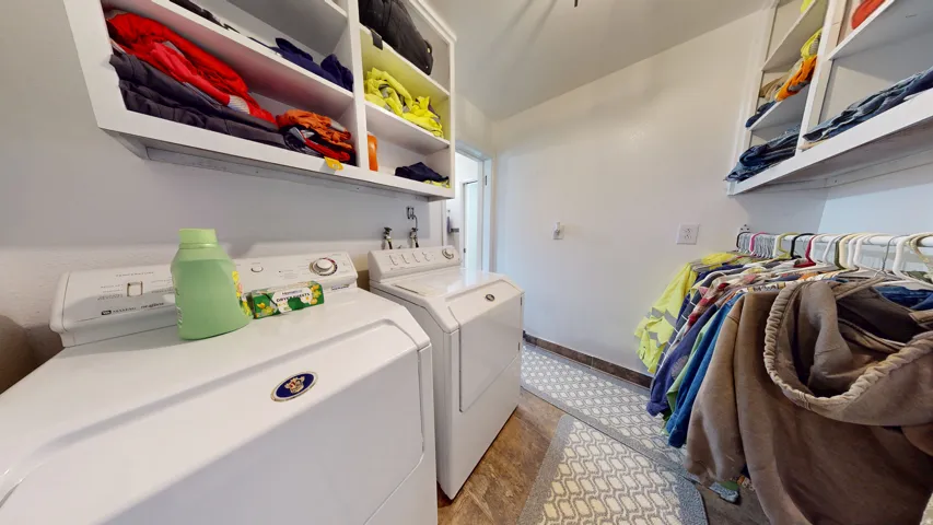 Dedicated laundry area featuring white cabinetry, built-in shelving, tile flooring, and white walls