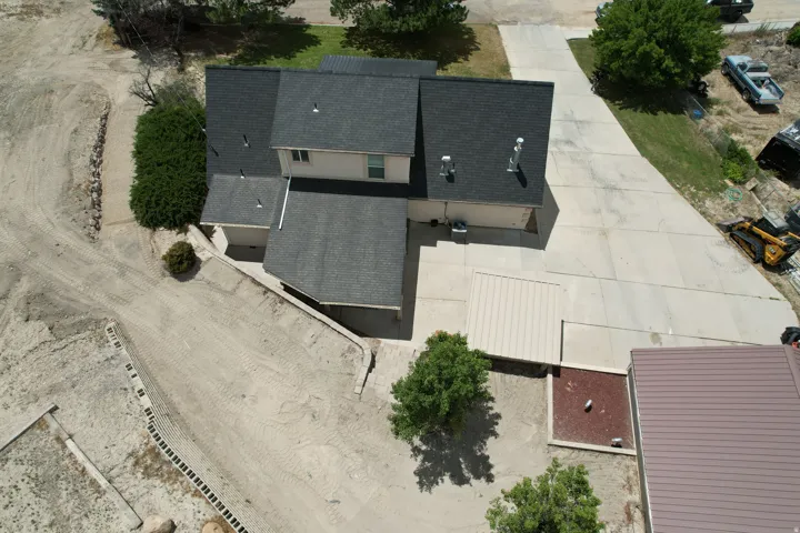 Two-story property with light-colored siding and a dark shingle roof