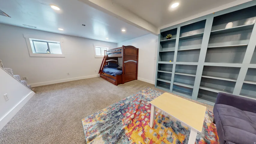 Spacious room featuring light gray carpeting and recessed lighting