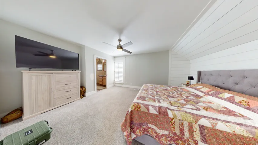 Spacious room featuring light-toned carpeting and a ceiling fan