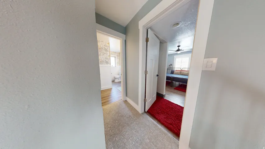 Hallway with carpet flooring, light blue wall paint, and white trim molding