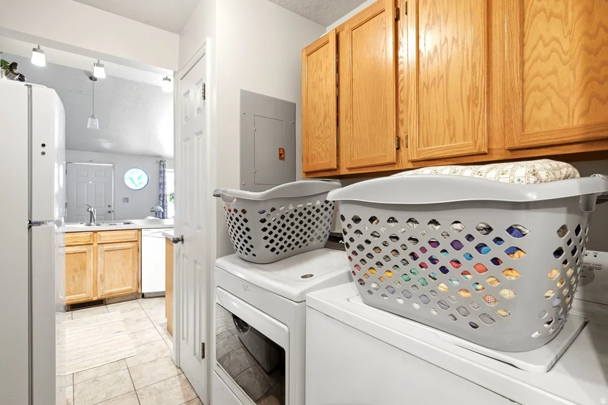 Laundry area featuring overhead wood cabinetry and tile flooring