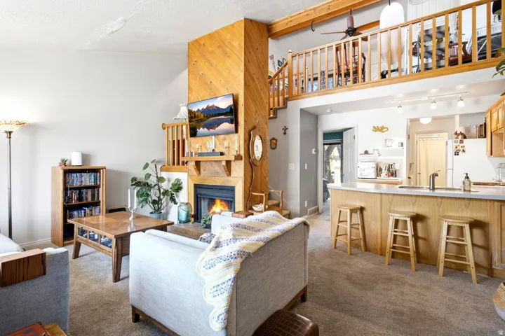 Open-concept living area with a natural wood-paneled fireplace surround and mantel
