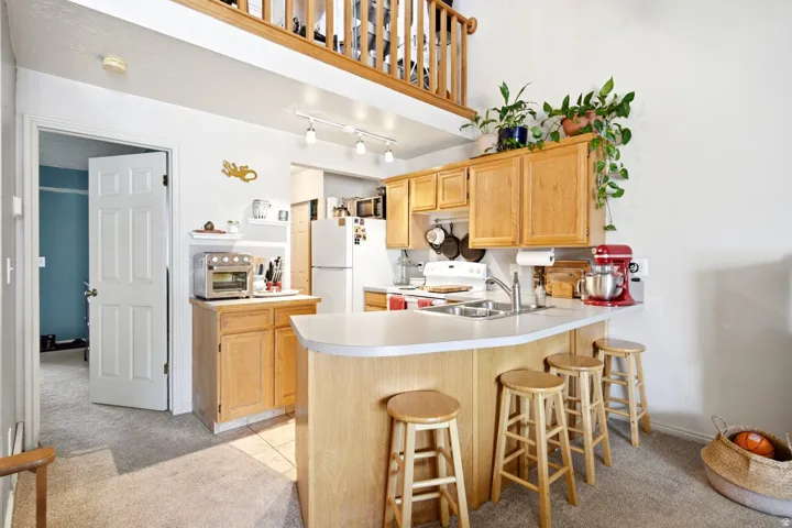 Kitchen featuring light wood-finish cabinetry and a white countertop with a breakfast bar