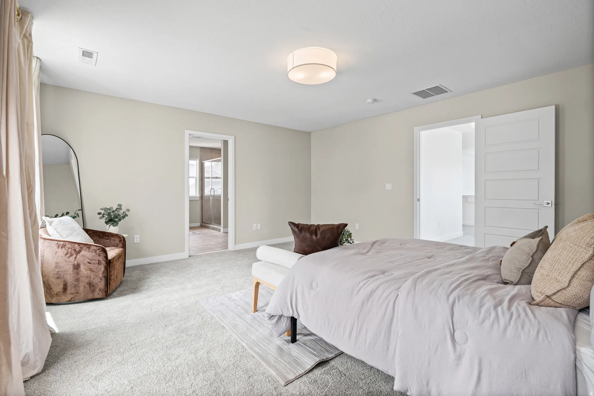 Expansive carpeted room featuring neutral wall tones, a contemporary ceiling light fixture, and white trim