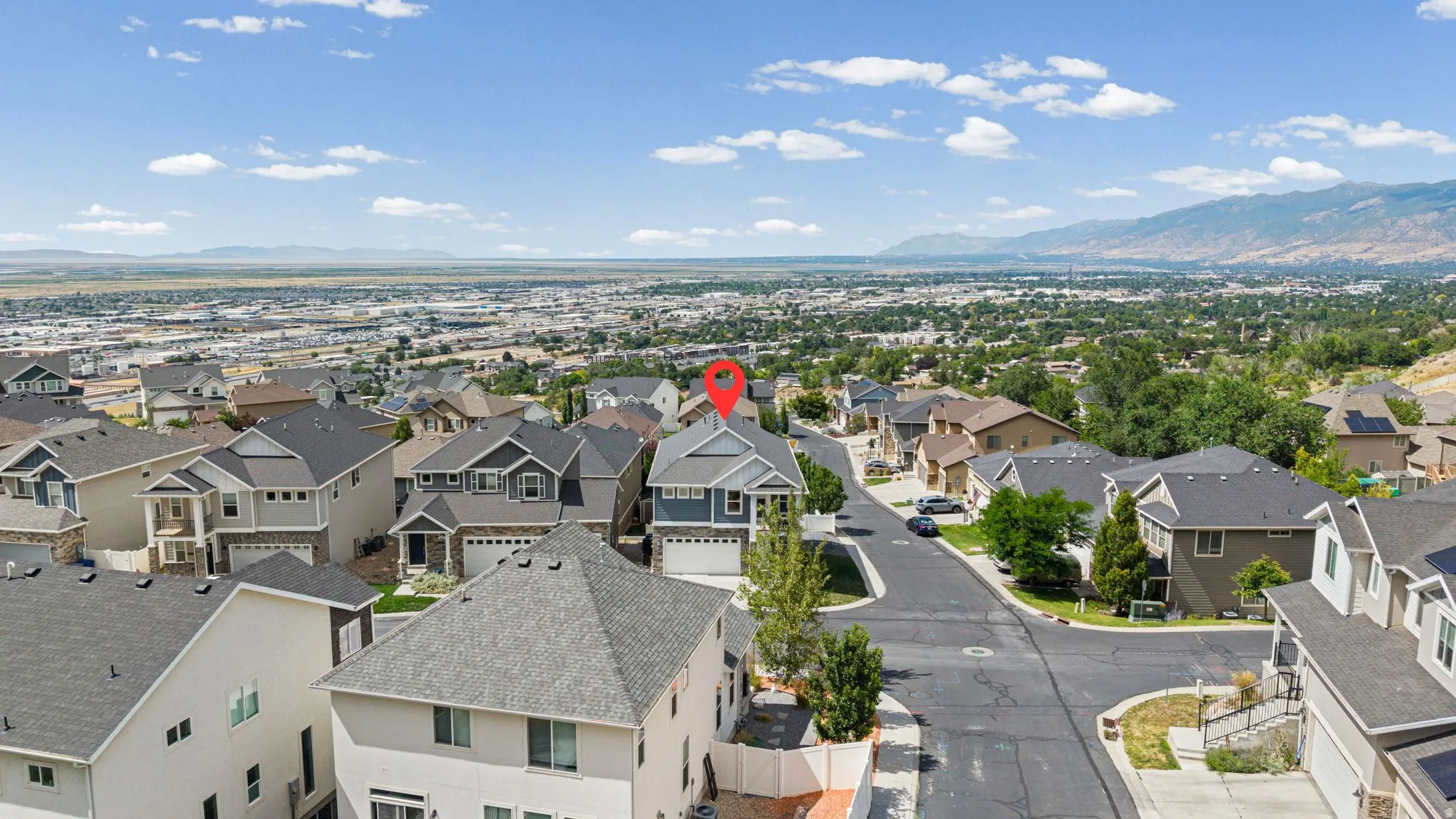 Aerial perspective showcasing a residential neighborhood with surrounding mountains and expansive urban landscape