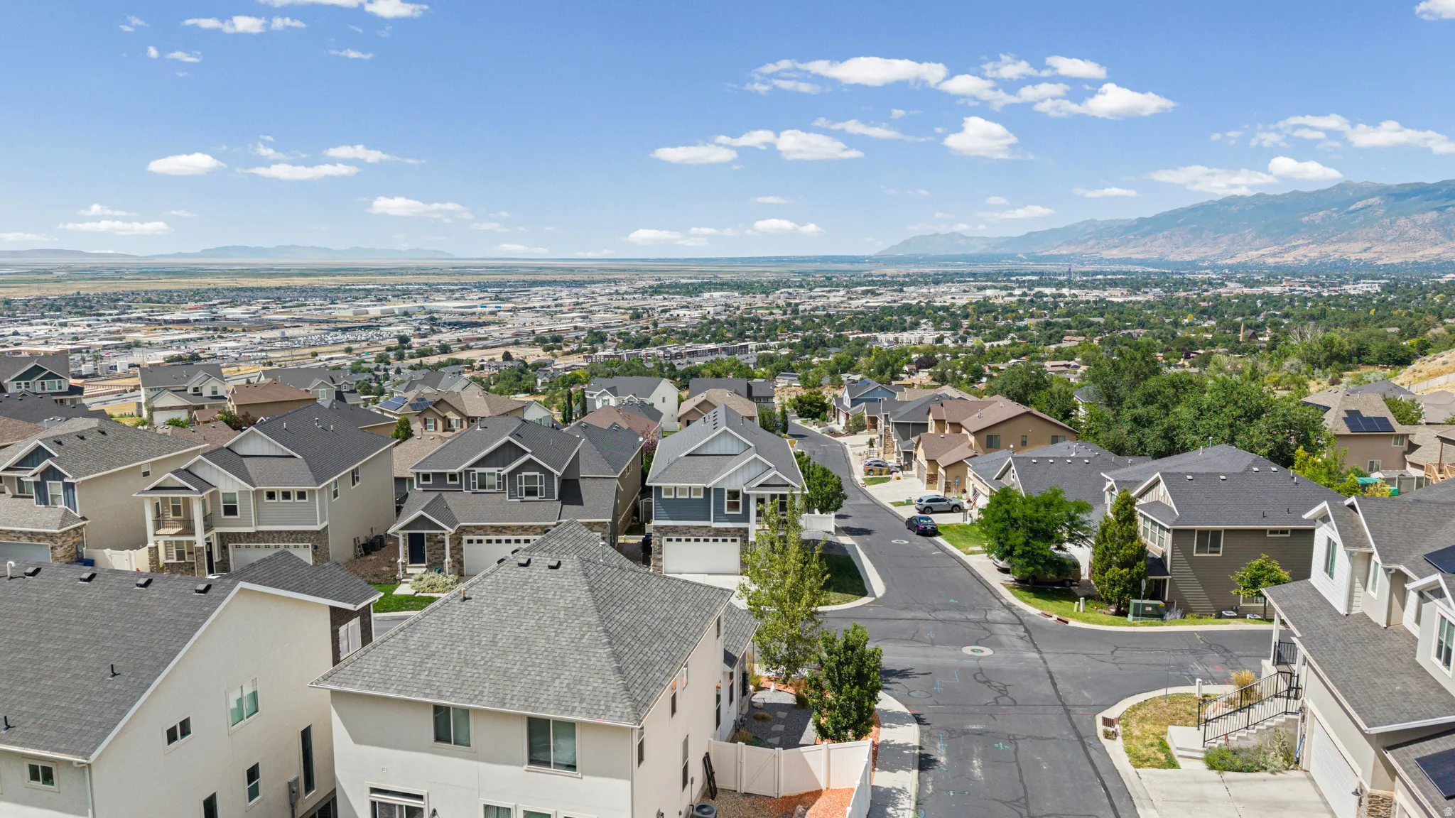 Expansive residential neighborhood featuring a variety of architectural styles, paved streets, and mountainous backdrops