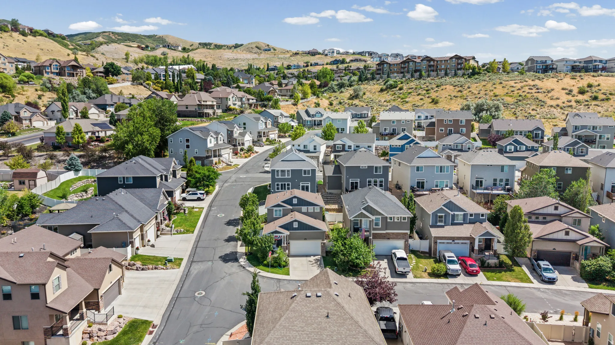Residential neighborhood featuring single-family homes with pitched roofs, varied siding materials, and attached garages