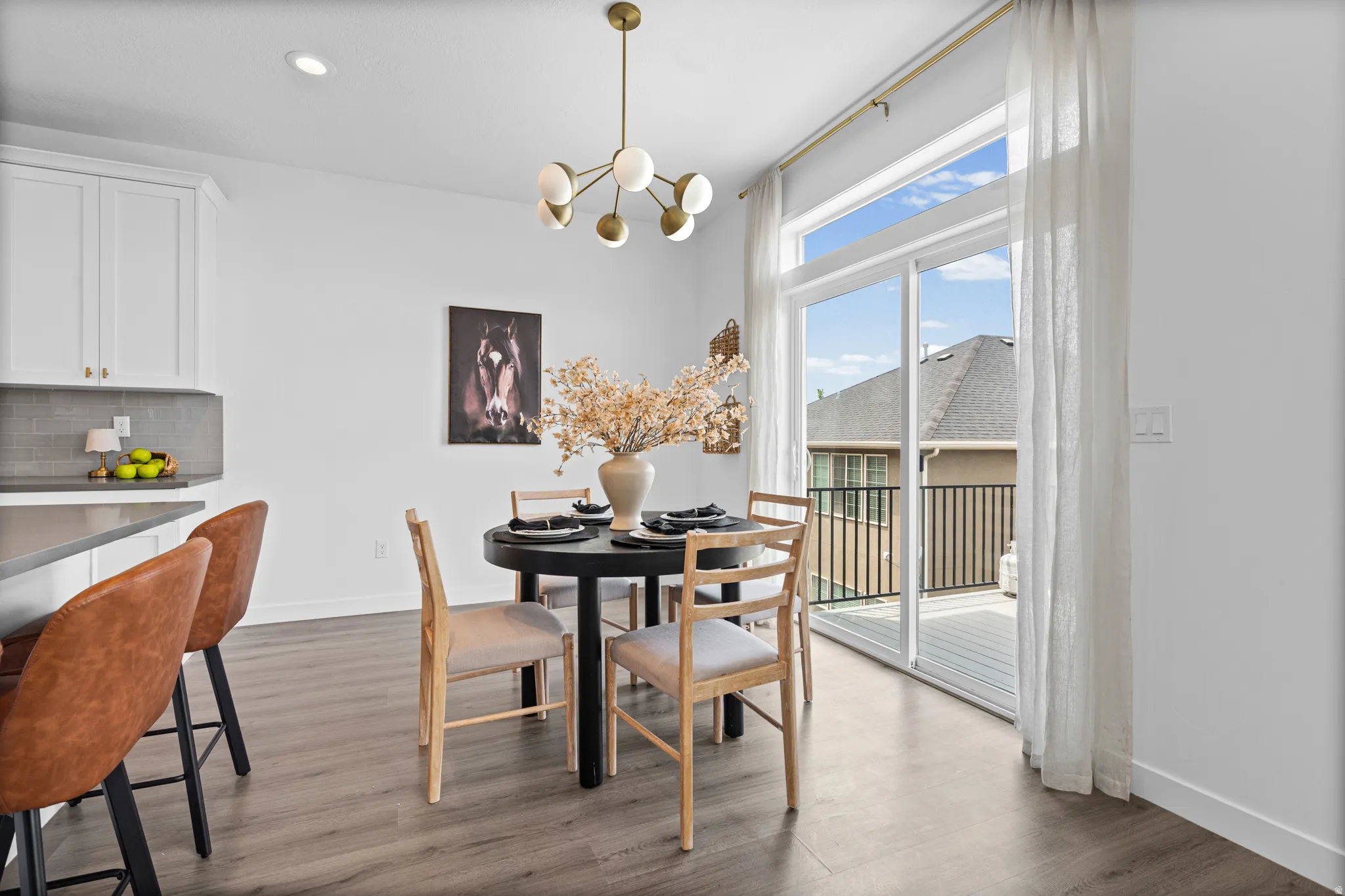 Dining area featuring a modern brass chandelier and wood-finish flooring