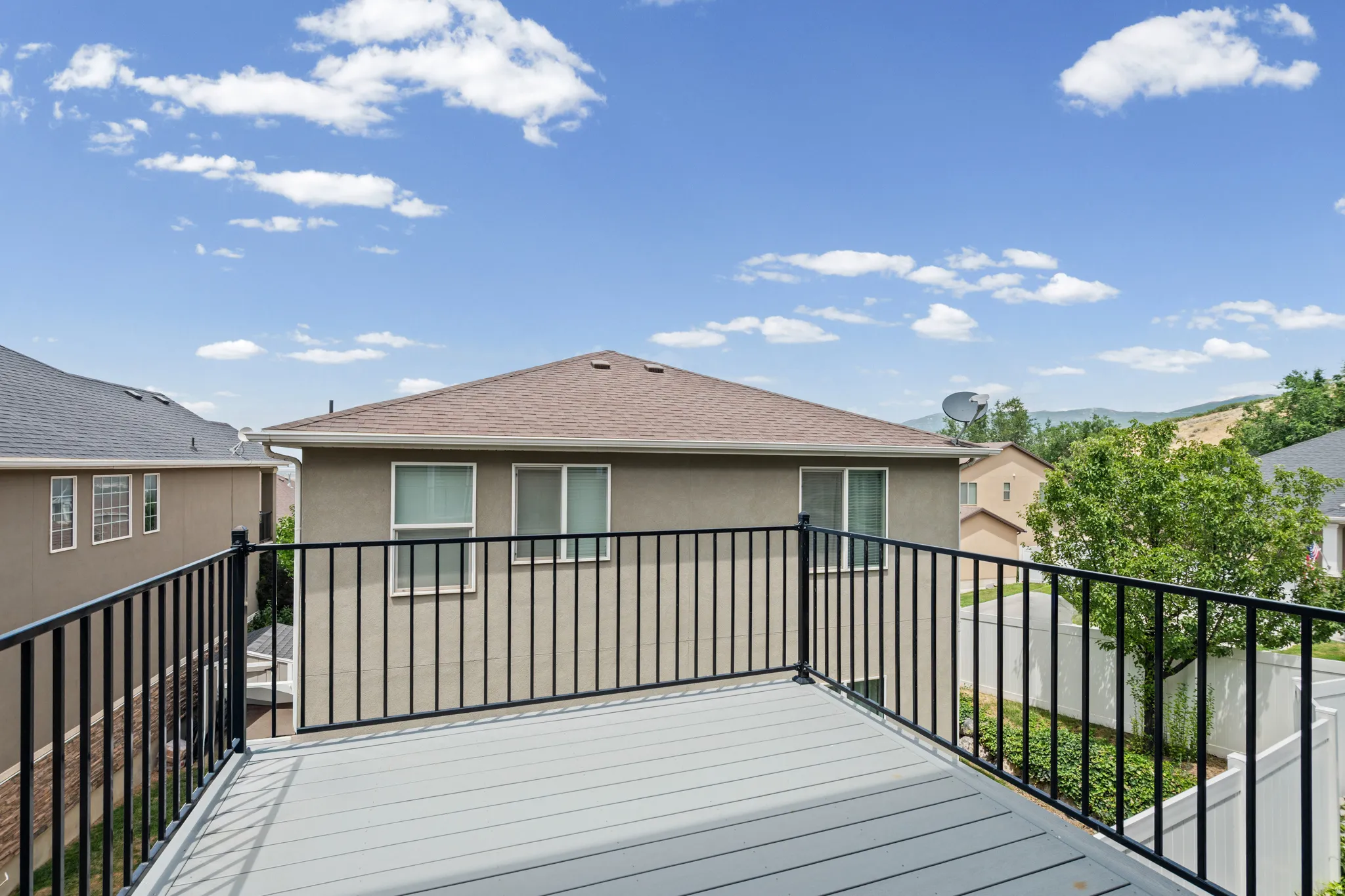 Outdoor deck featuring composite flooring and black metal railings