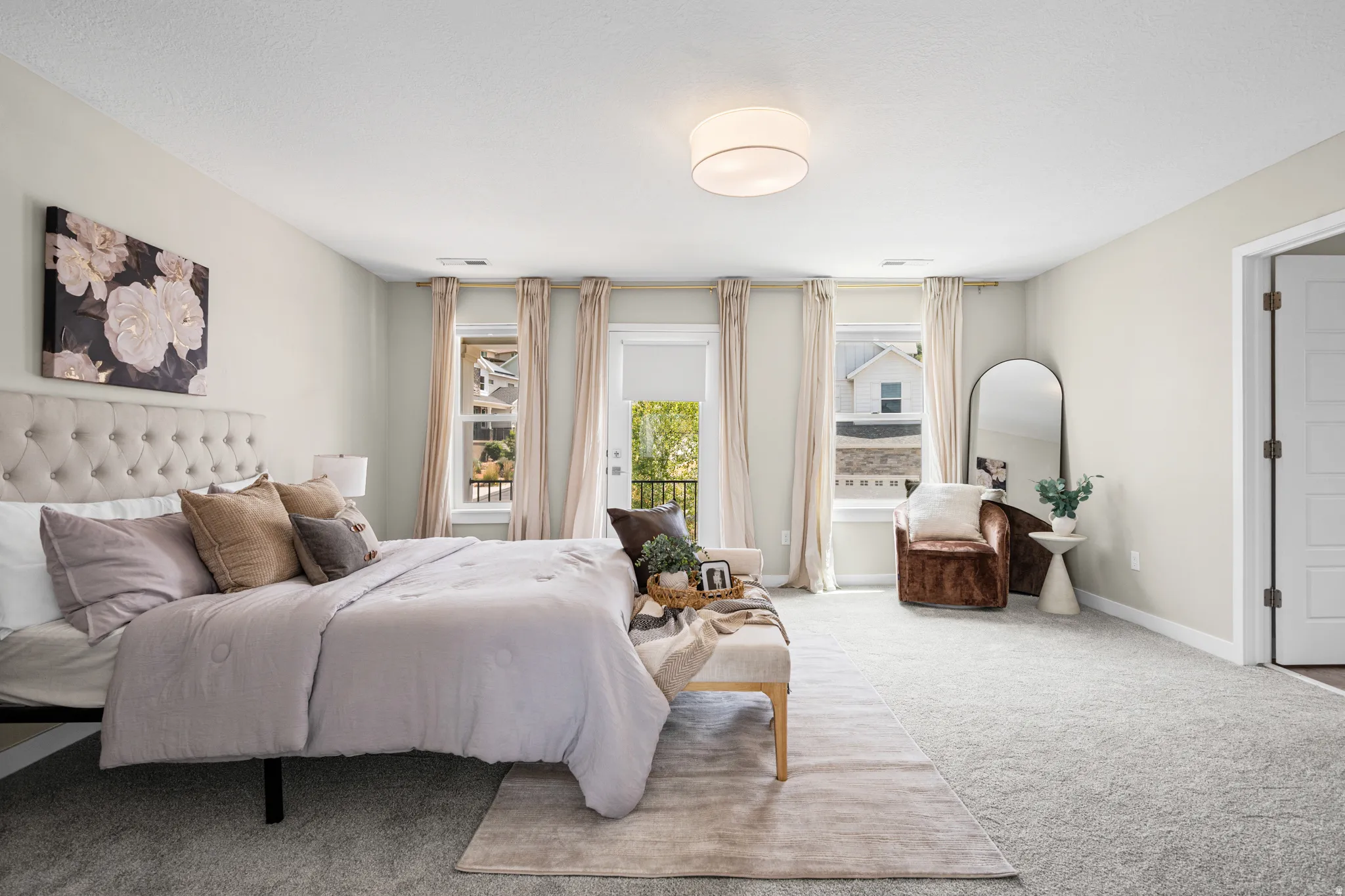 Carpeted bedroom featuring a tufted headboard, drum ceiling light fixture, and a balcony access door