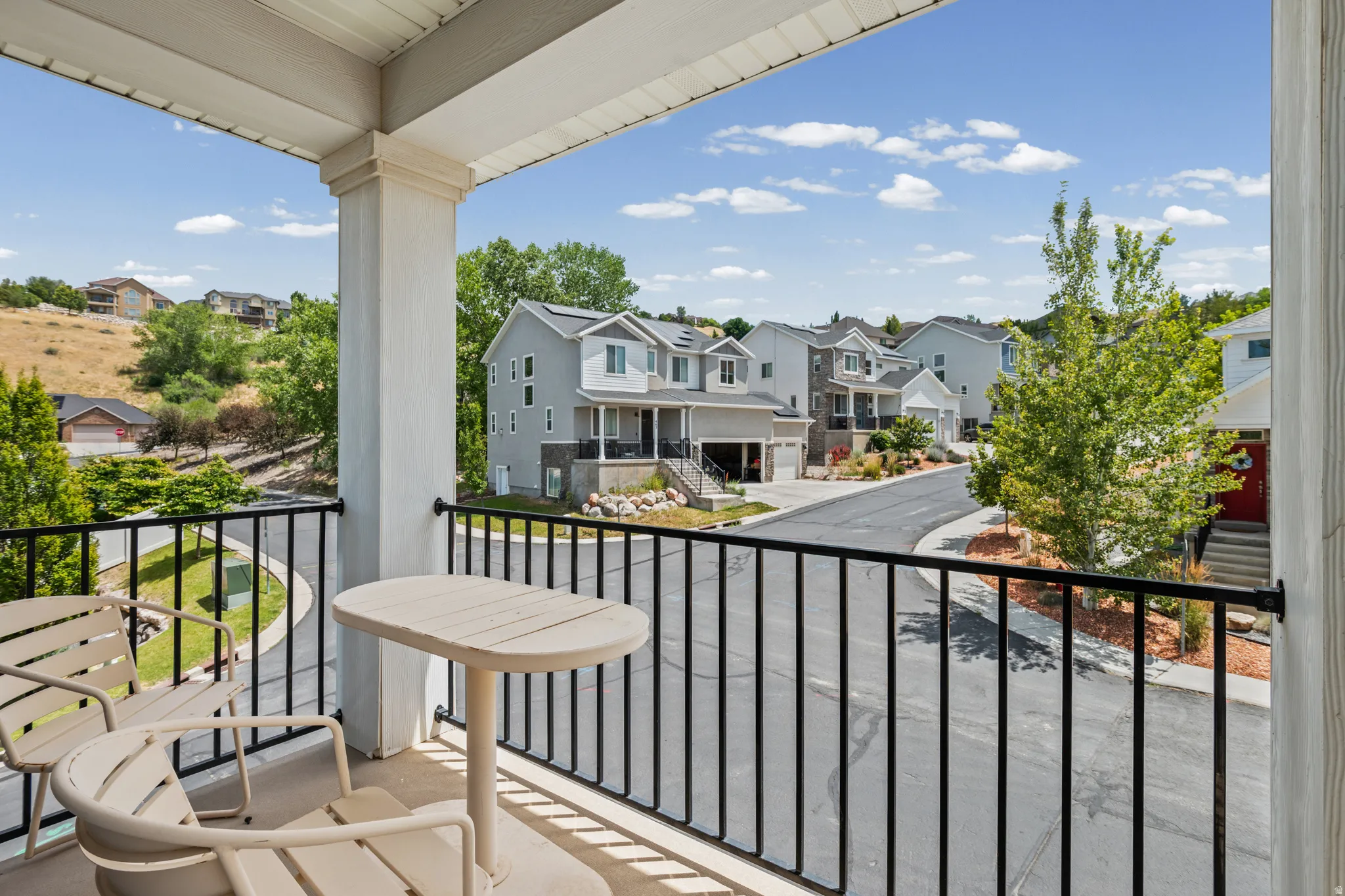 Upper-level balcony featuring black wrought iron railings and white support columns