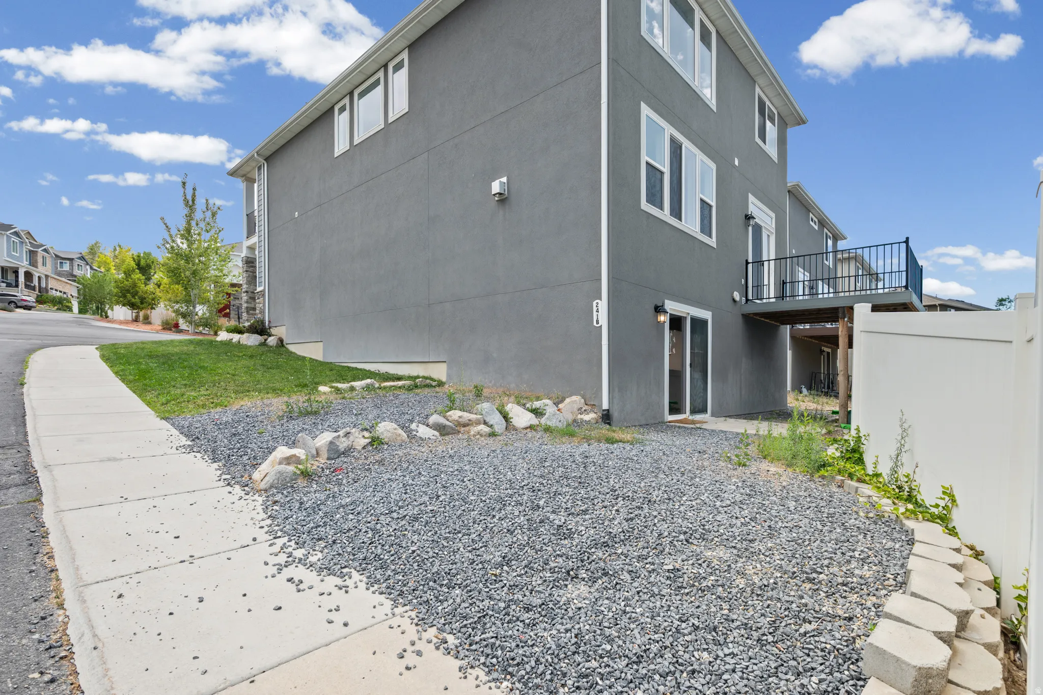 Stucco exterior featuring multiple windows and a balcony with black metal railing