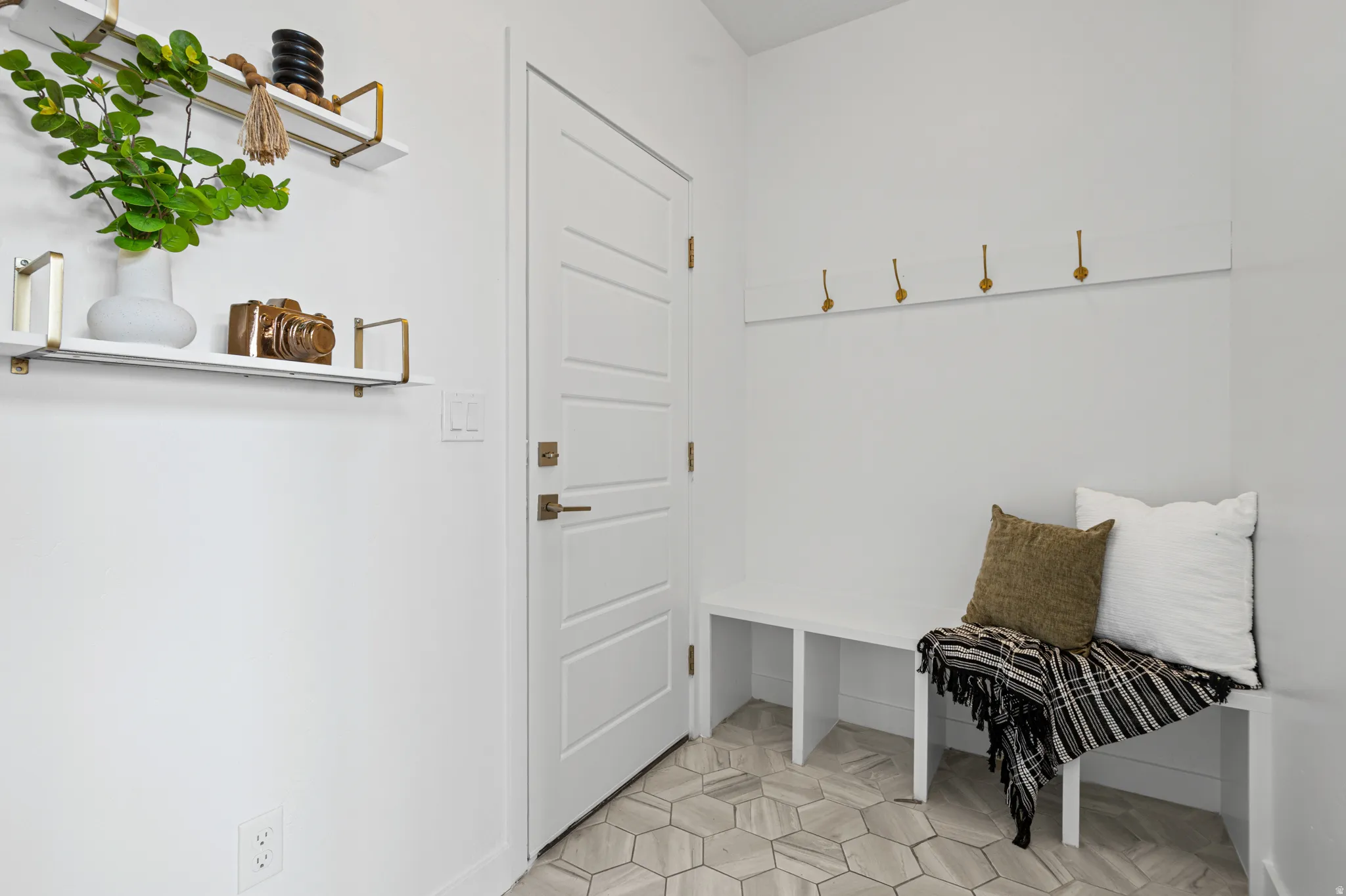 Entryway featuring a built-in bench, hexagonal tile flooring, and integrated wall hooks