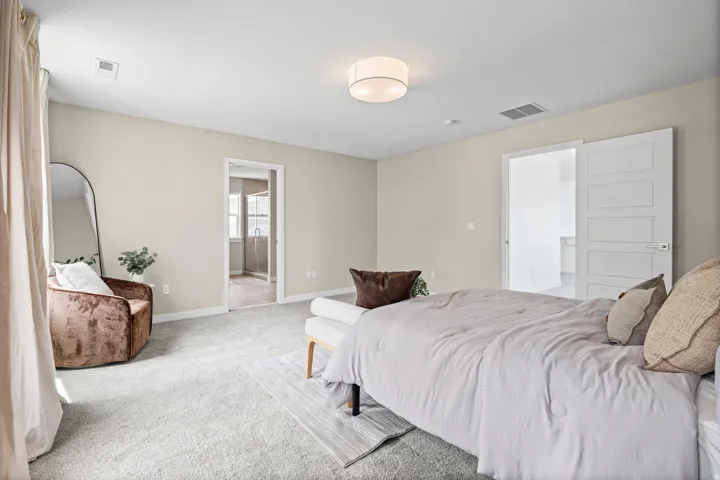 Expansive carpeted room featuring neutral wall tones, a contemporary ceiling light fixture, and white trim
