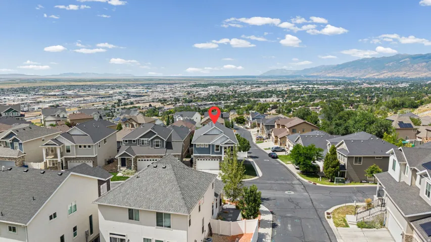 Aerial perspective showcasing a residential neighborhood with surrounding mountains and expansive urban landscape