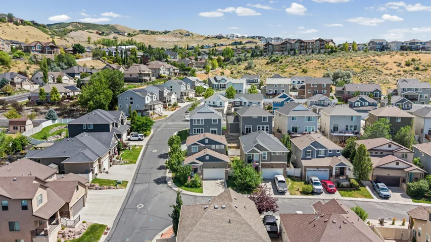 Residential neighborhood featuring single-family homes with pitched roofs, varied siding materials, and attached garages