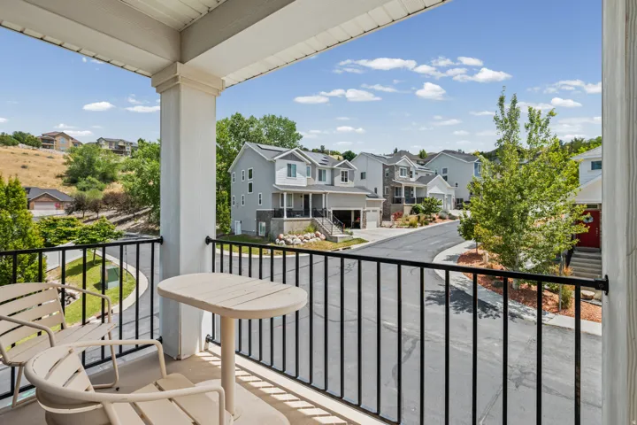 Upper-level balcony featuring black wrought iron railings and white support columns