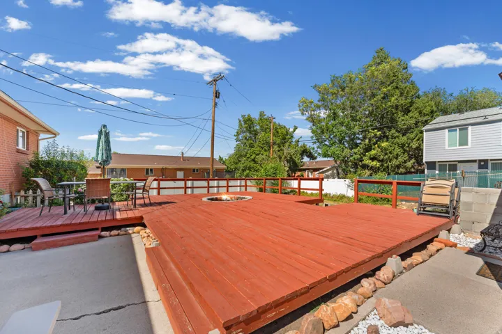 Multi-level wood deck featuring a built-in fire pit, surrounded by a wood railing