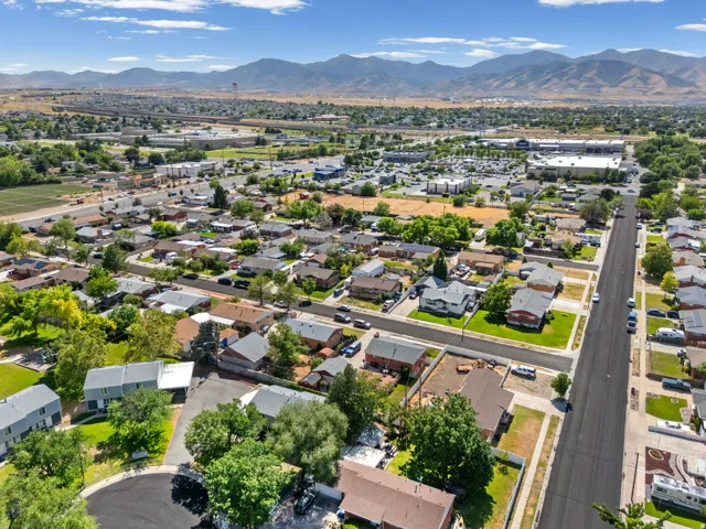 Aerial perspective showcasing a residential neighborhood with surrounding commercial developments and distant mountains
