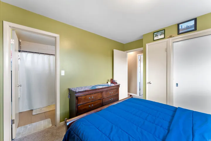 Bedroom featuring neutral carpeting and light green walls