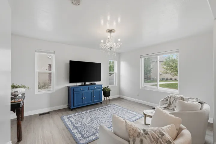 Bright living space featuring wood-finish flooring and a central chandelier