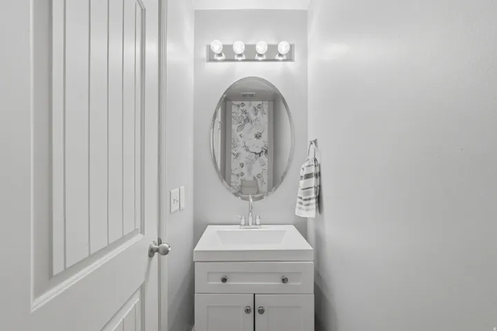 Vanity area featuring a white cabinet with brushed nickel hardware, an integrated sink, and a chrome faucet