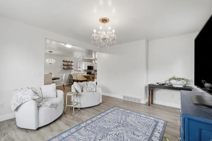 Living area with wood-finish flooring and a decorative chandelier
