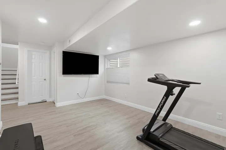 Versatile recreational space featuring light wood-finish flooring and recessed ceiling lighting