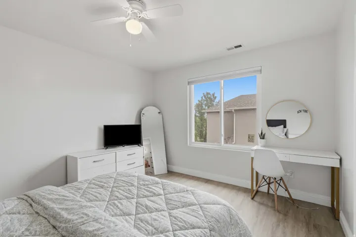 Bright room featuring a large window, a ceiling fan with integrated lighting, recessed lighting, and wood-finish flooring