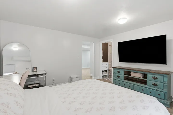 Spacious room with light-toned walls and wood-finish flooring