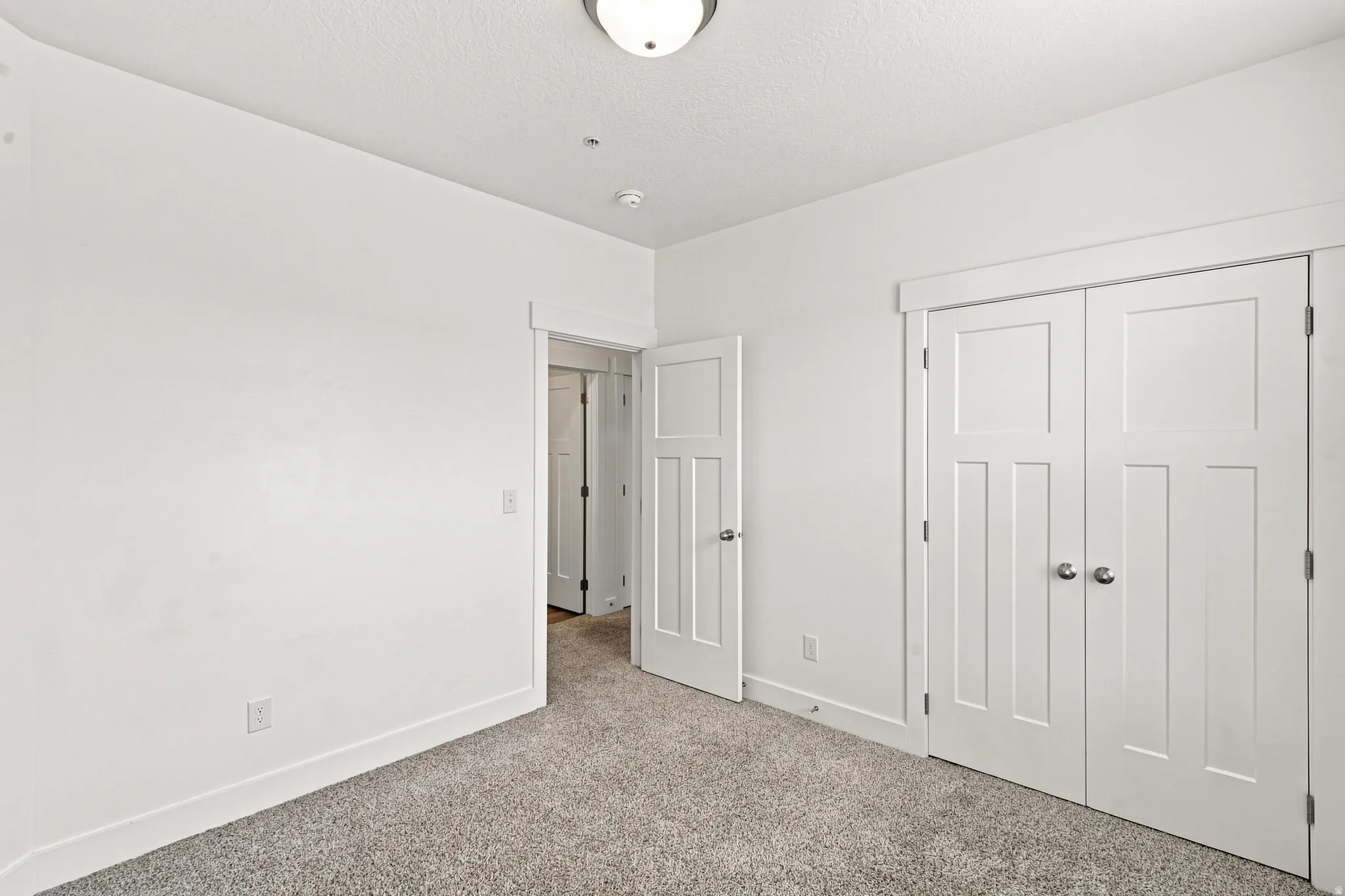 Interior room featuring light gray carpet, white walls, and white trim