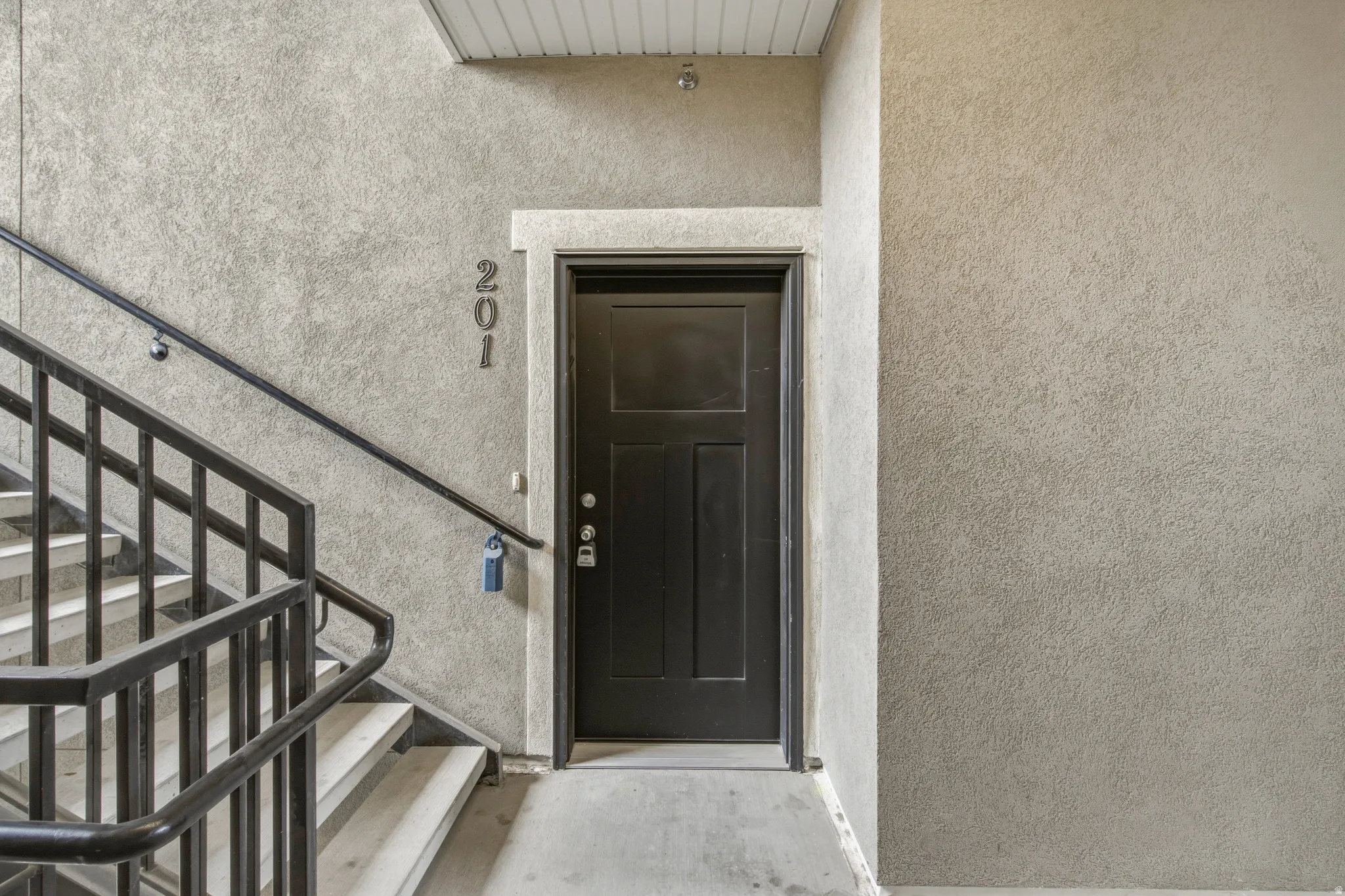 Entryway featuring a paneled door, stucco finish walls, and concrete flooring